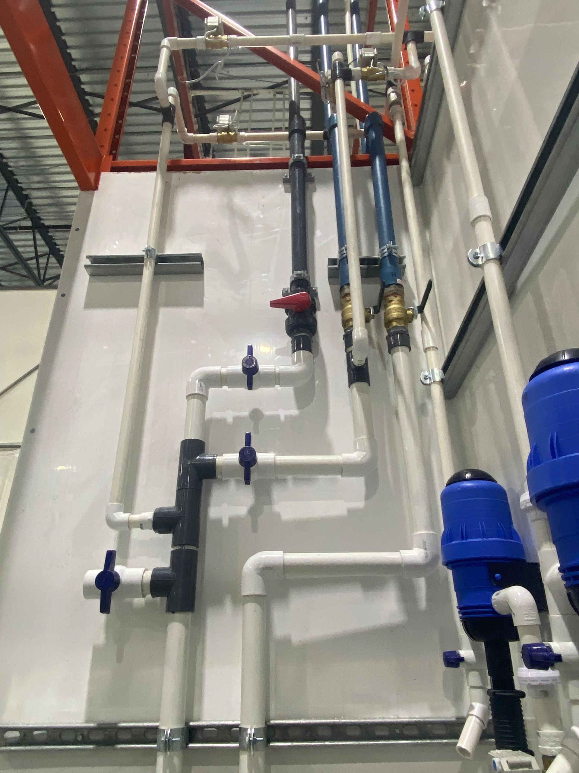 Un tas de tuyaux sont suspendus au plafond d’un immeuble.