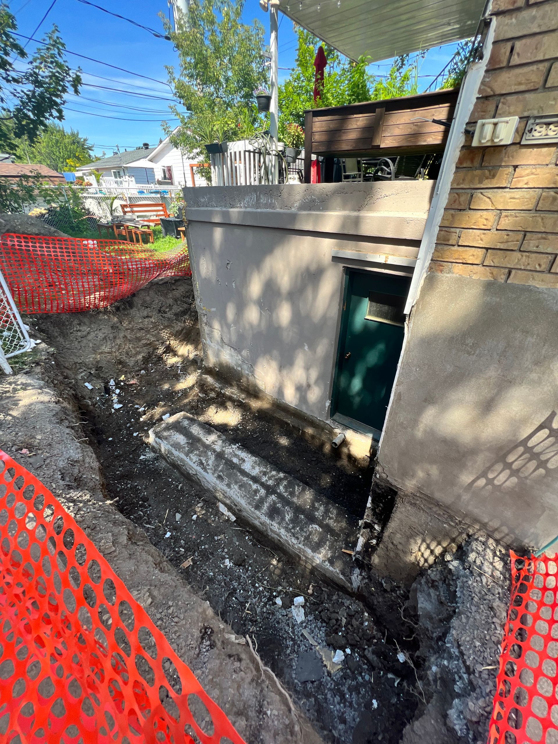 Il y a un trou dans le sol devant un bâtiment en brique.