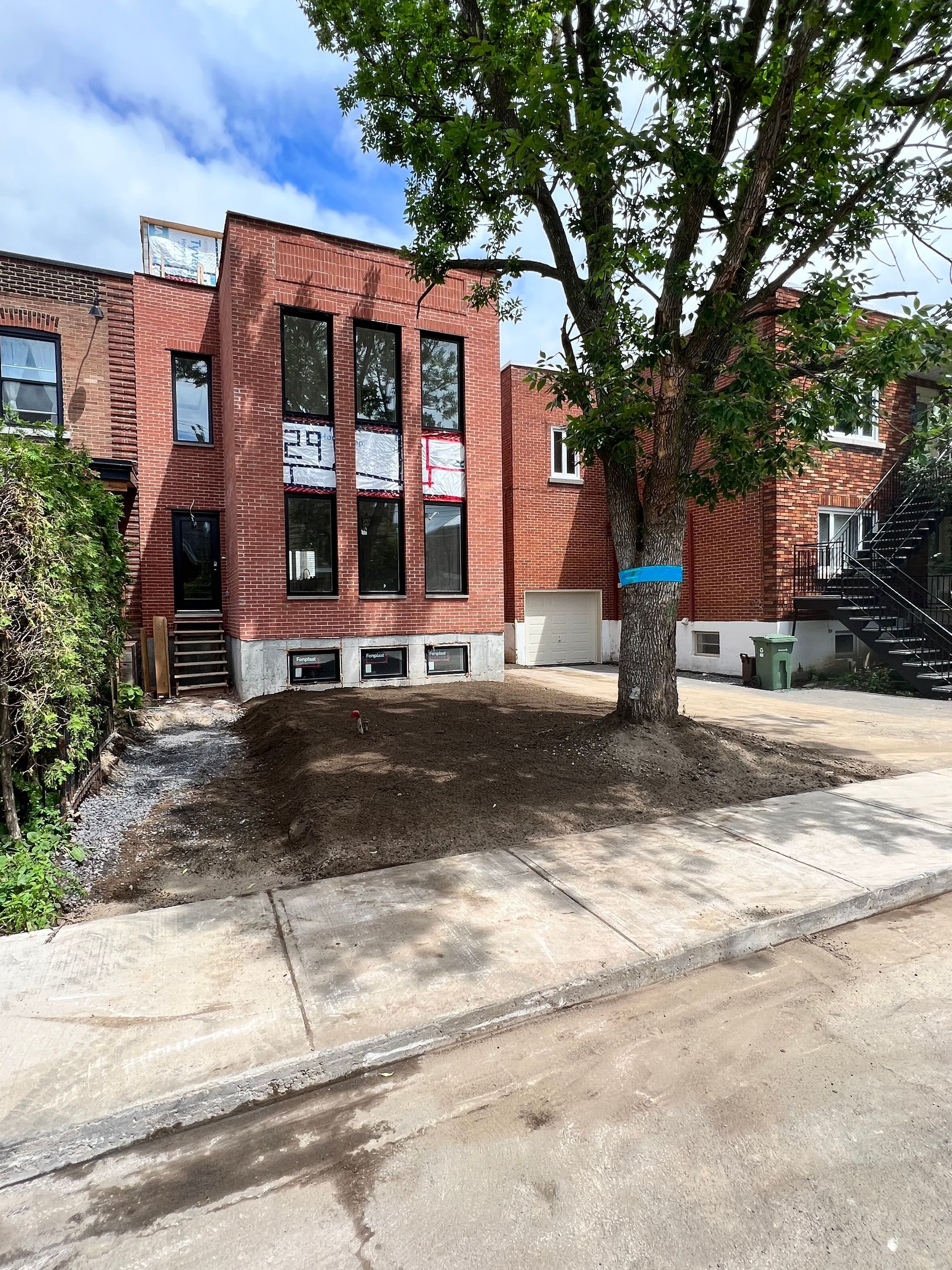 Un bâtiment en brique avec un arbre devant lui