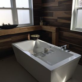 Une baignoire dans une salle de bain à côté d une fenêtre