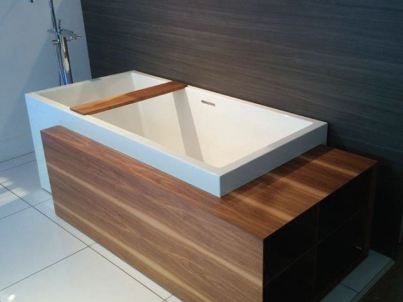 Une baignoire avec une étagère en bois en dessous