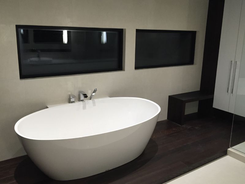 Une salle de bain avec baignoire et deux fenêtres