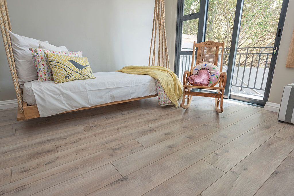 A living room with hardwood floors , a couch , chairs , and a coffee table.