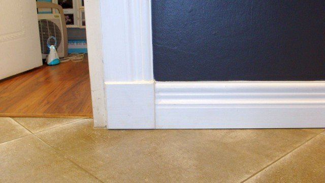 A doorway with a tile floor and a black wall.