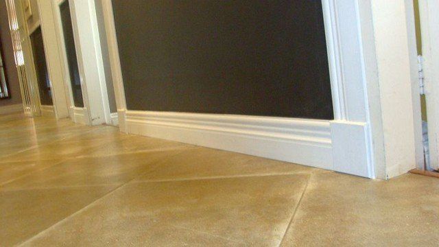 A hallway with tile floors and a blackboard on the wall.