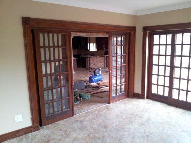 A room with sliding glass doors and a blue air compressor.