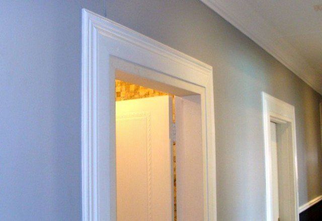 A hallway with a white door and gray walls.