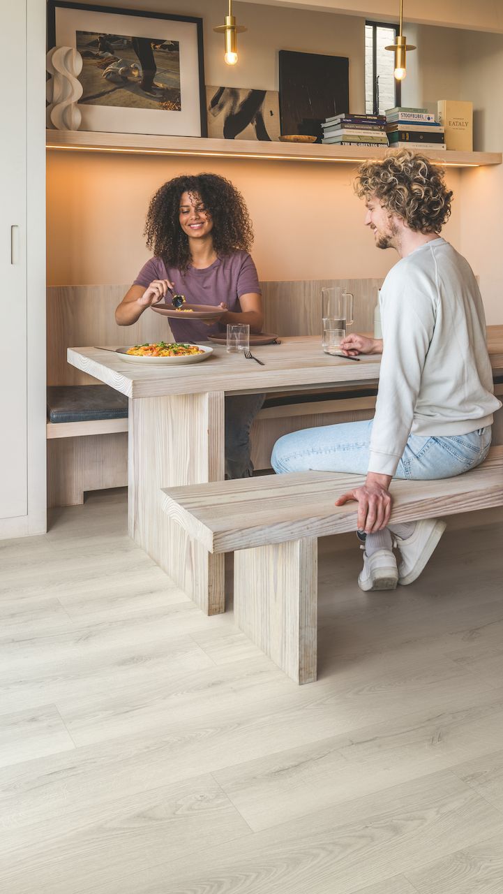 A man and a woman are sitting at a table eating food.