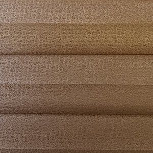 A close up of a brown blind with a pattern on it.