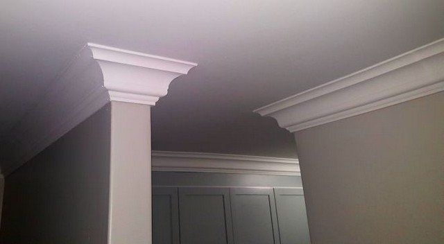 A room with two columns and a ceiling with crown molding.