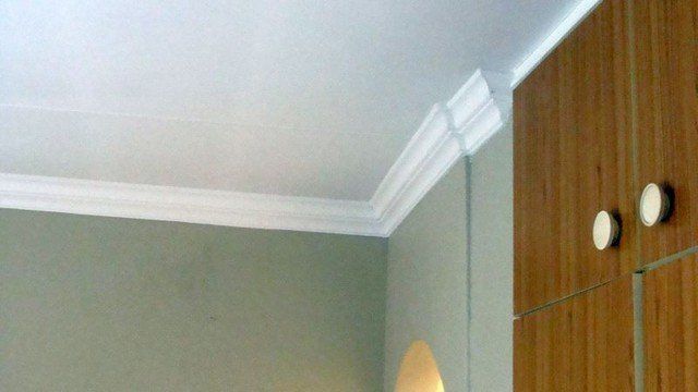 A room with a white ceiling and wooden cabinets.