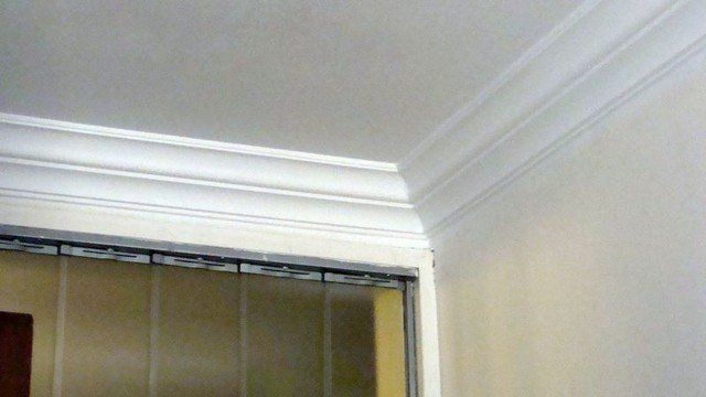 A room with a ceiling and a door with blinds on it.