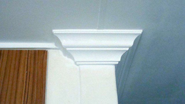 A white crown molding is on the corner of a wall.