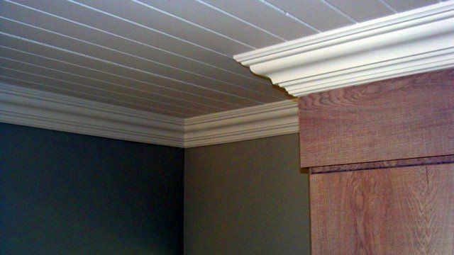 A room with a wooden ceiling and a white molding.