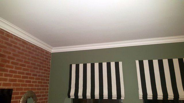 A room with striped curtains and a brick wall