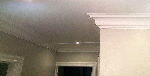 A hallway with a ceiling and a door in a house.