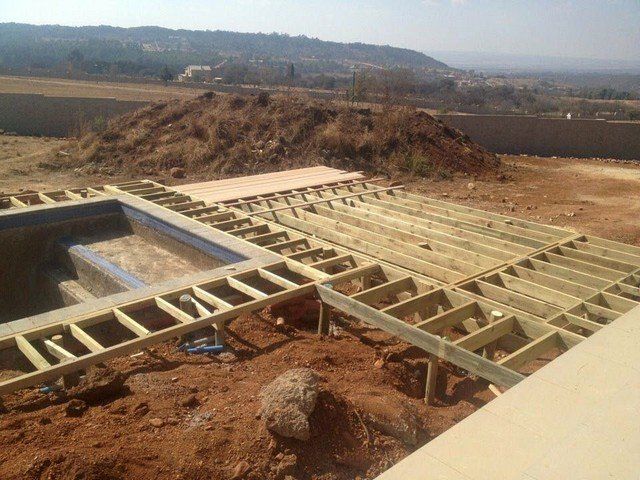 A wooden deck is being built over a swimming pool.