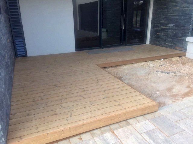 A wooden deck is being built in front of a building.