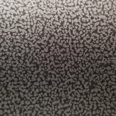 A close up of a black surface with a leopard print.