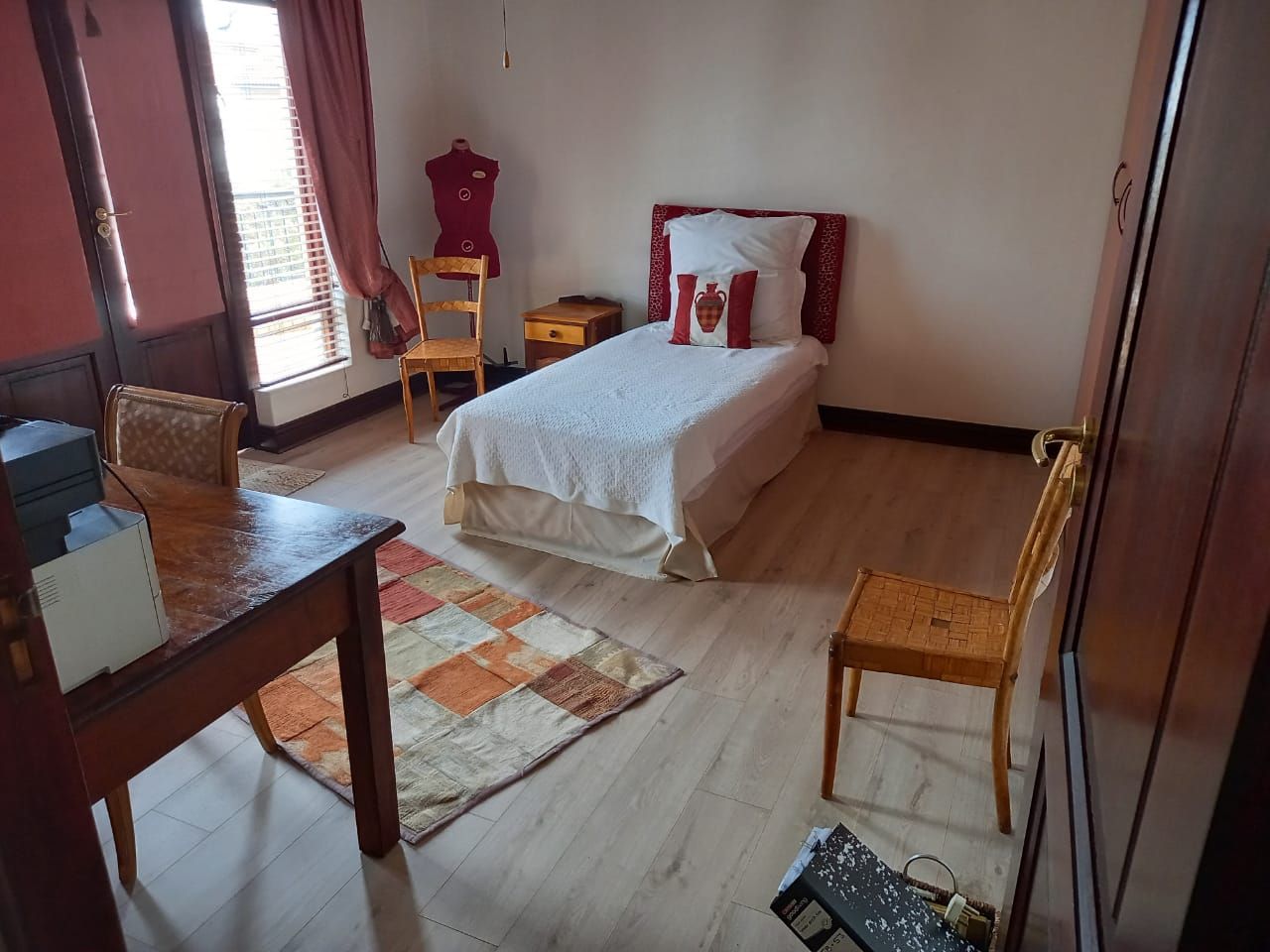 A bedroom with a single bed and a canadian flag on the bed.