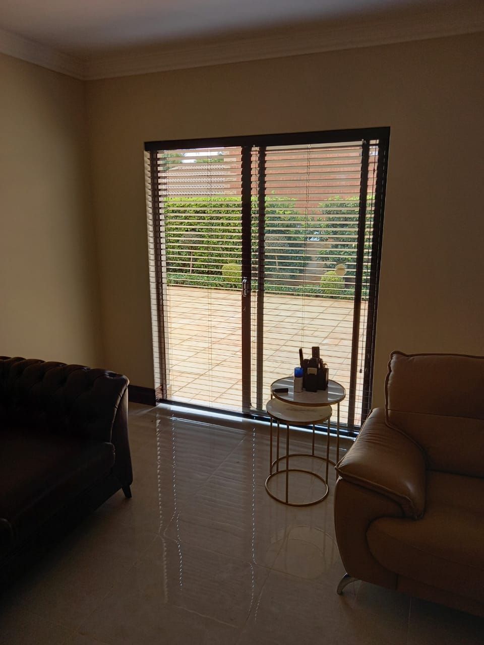 A living room with a couch and a table in front of a sliding glass door.