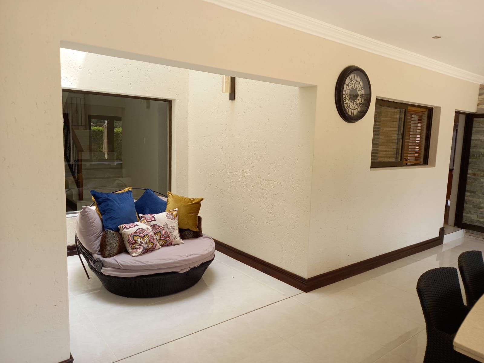 A living room with a chair and a clock on the wall.