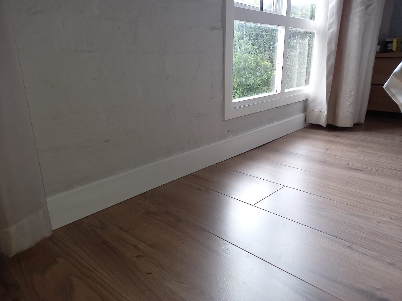 A room with a wooden floor and a window
