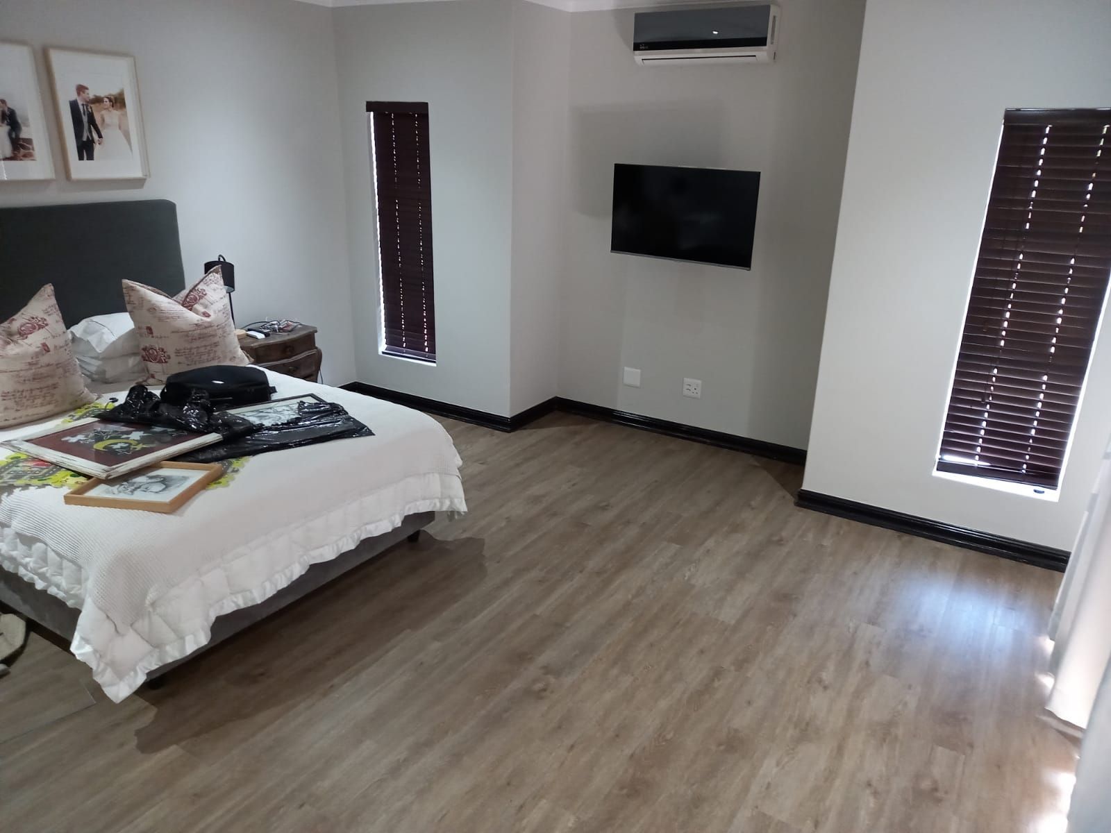 A bedroom with a bed and a television on the wall