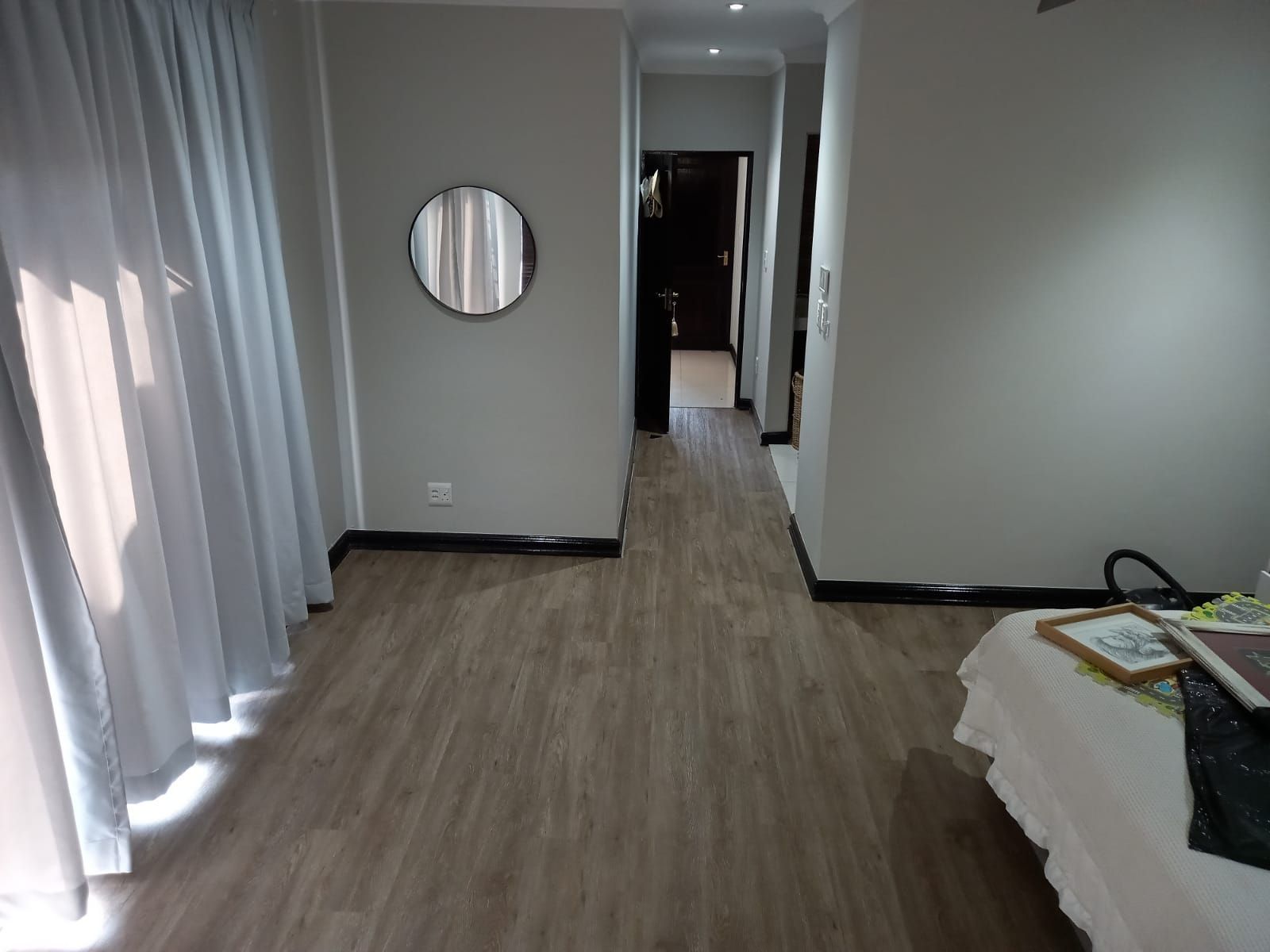 A bedroom with a bed and a mirror on the wall.