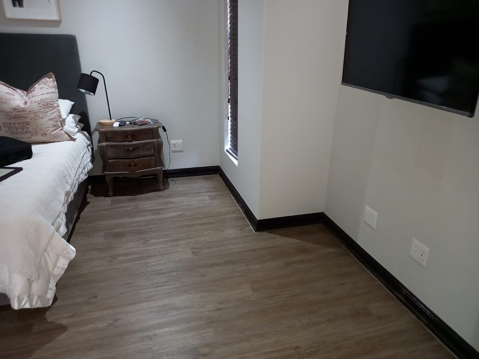 A bedroom with a bed and a television on the wall.