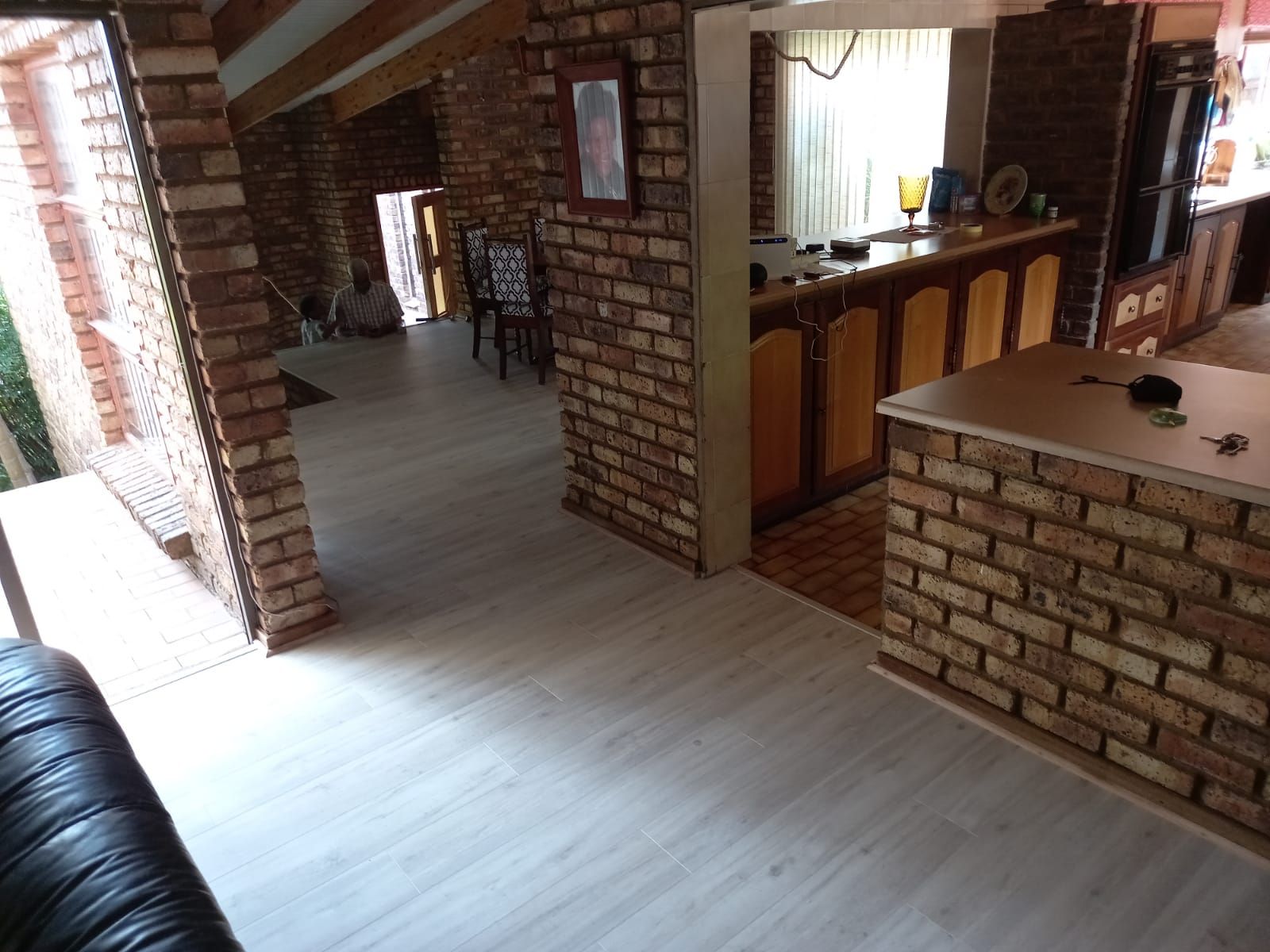 A living room with a brick wall and a white floor
