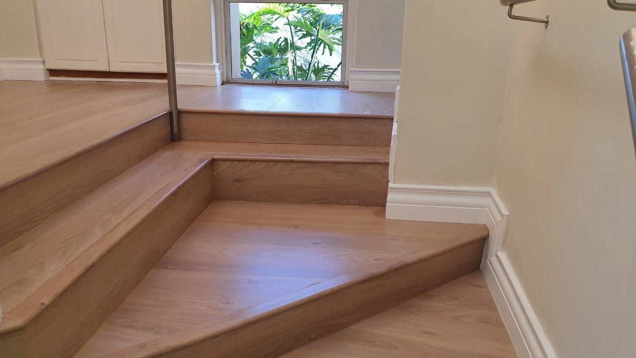 A set of wooden stairs leading up to a window.