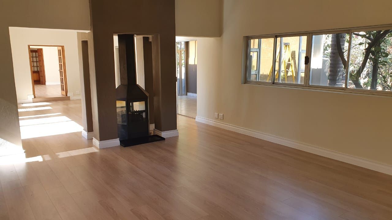 An empty living room with hardwood floors and a fireplace.