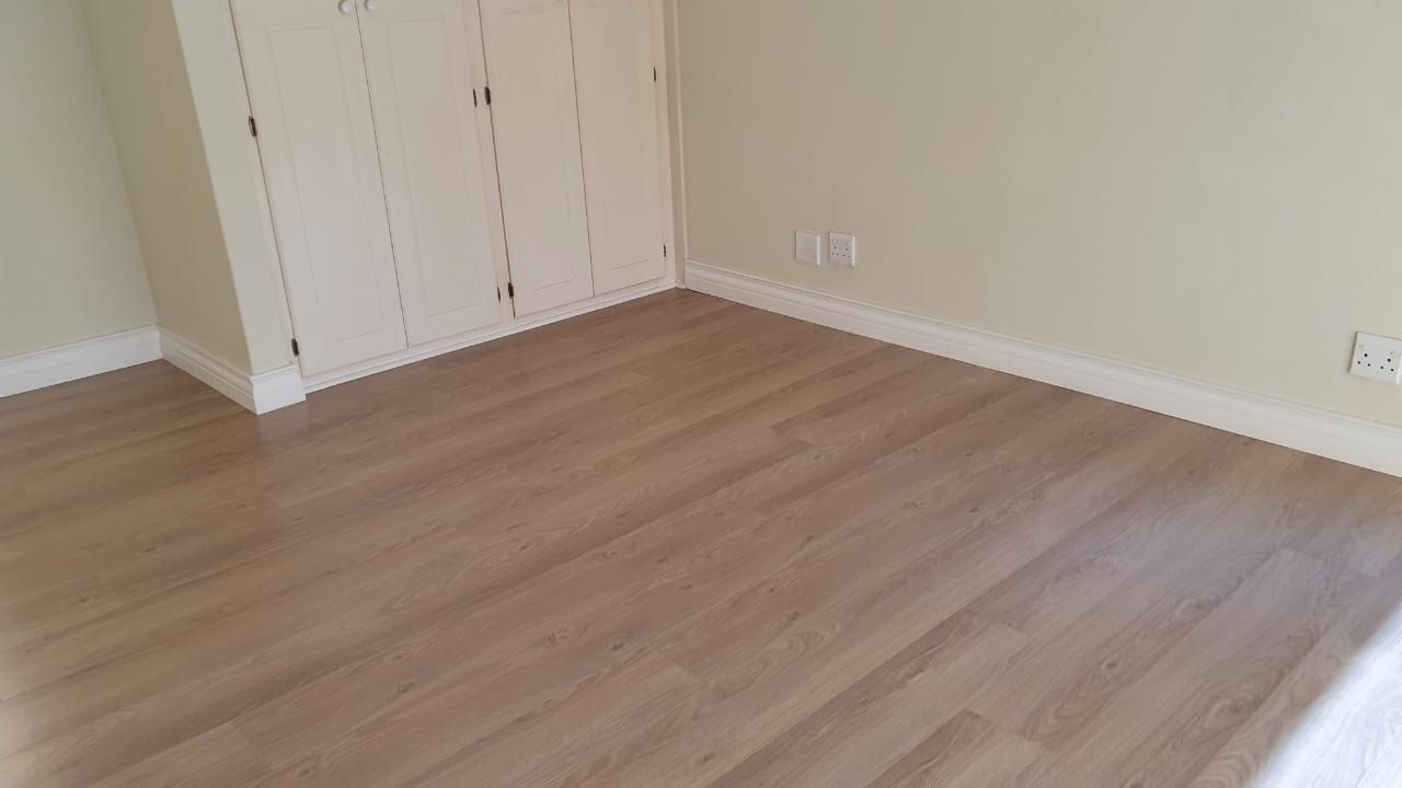 An empty room with hardwood floors and white walls.