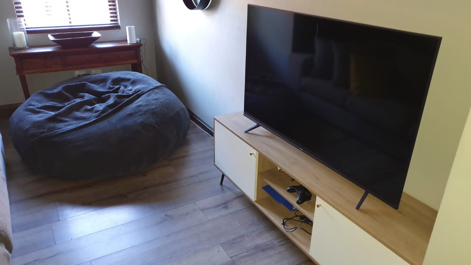 A living room with a bean bag chair and a flat screen tv