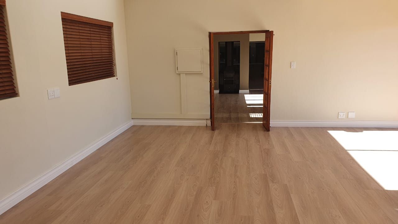An empty room with a wooden floor and a door