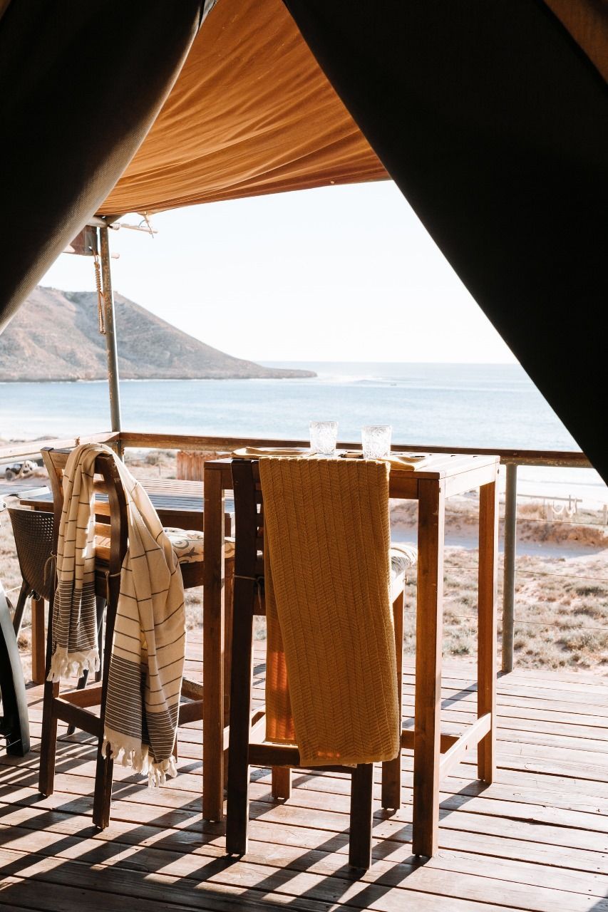 A table and chairs on a deck overlooking the ocean