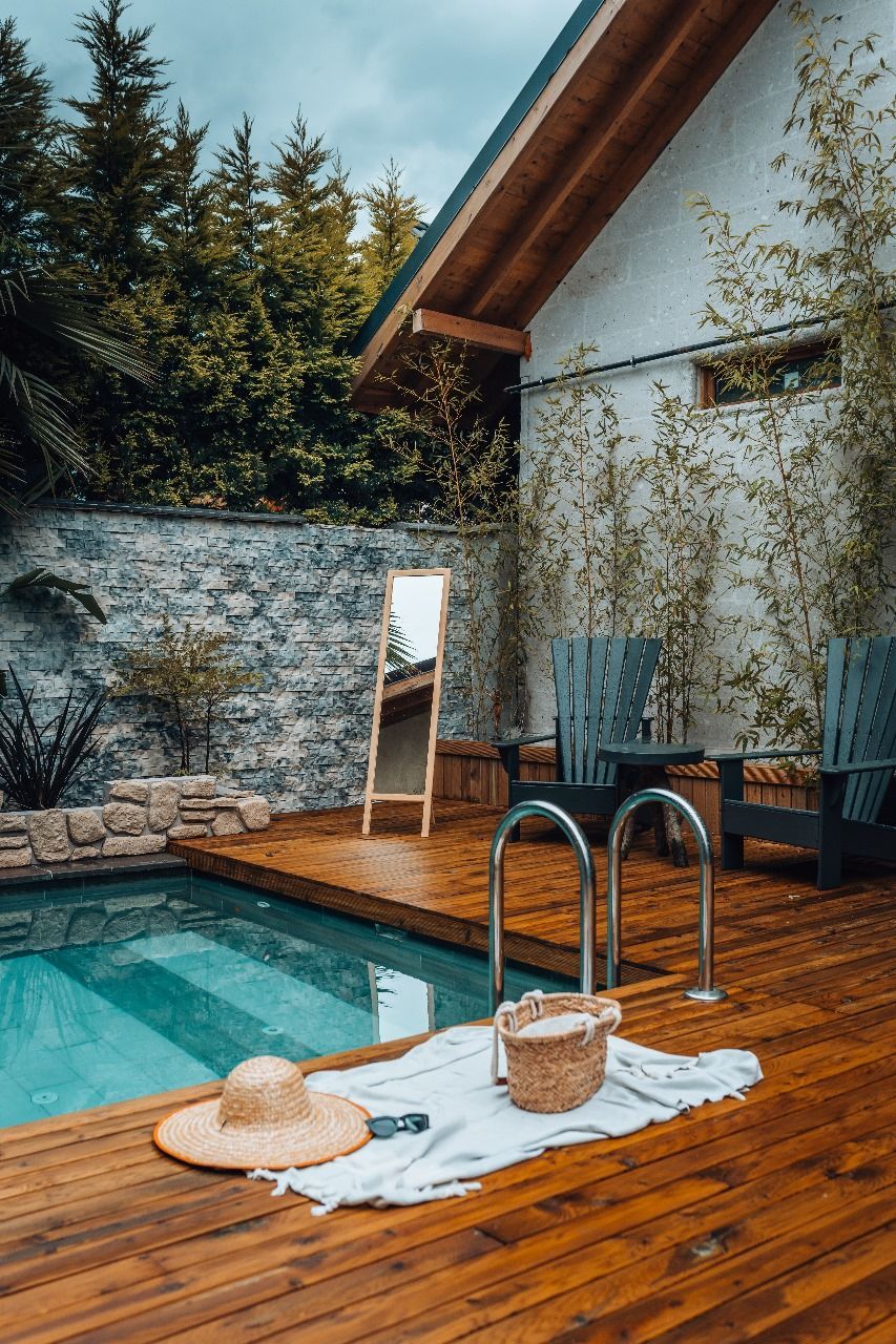 There is a swimming pool in the backyard of a house.