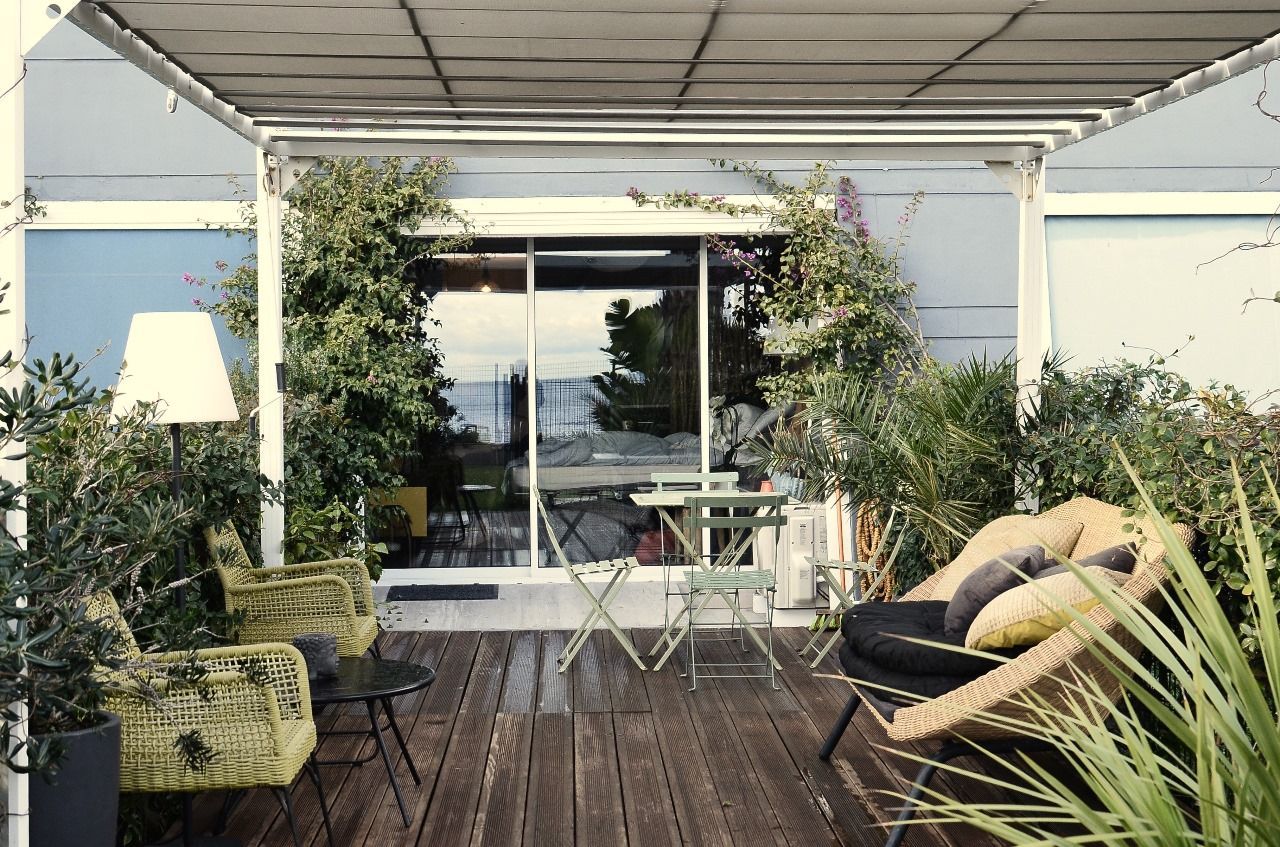 A patio with a pergola , chairs , tables and plants