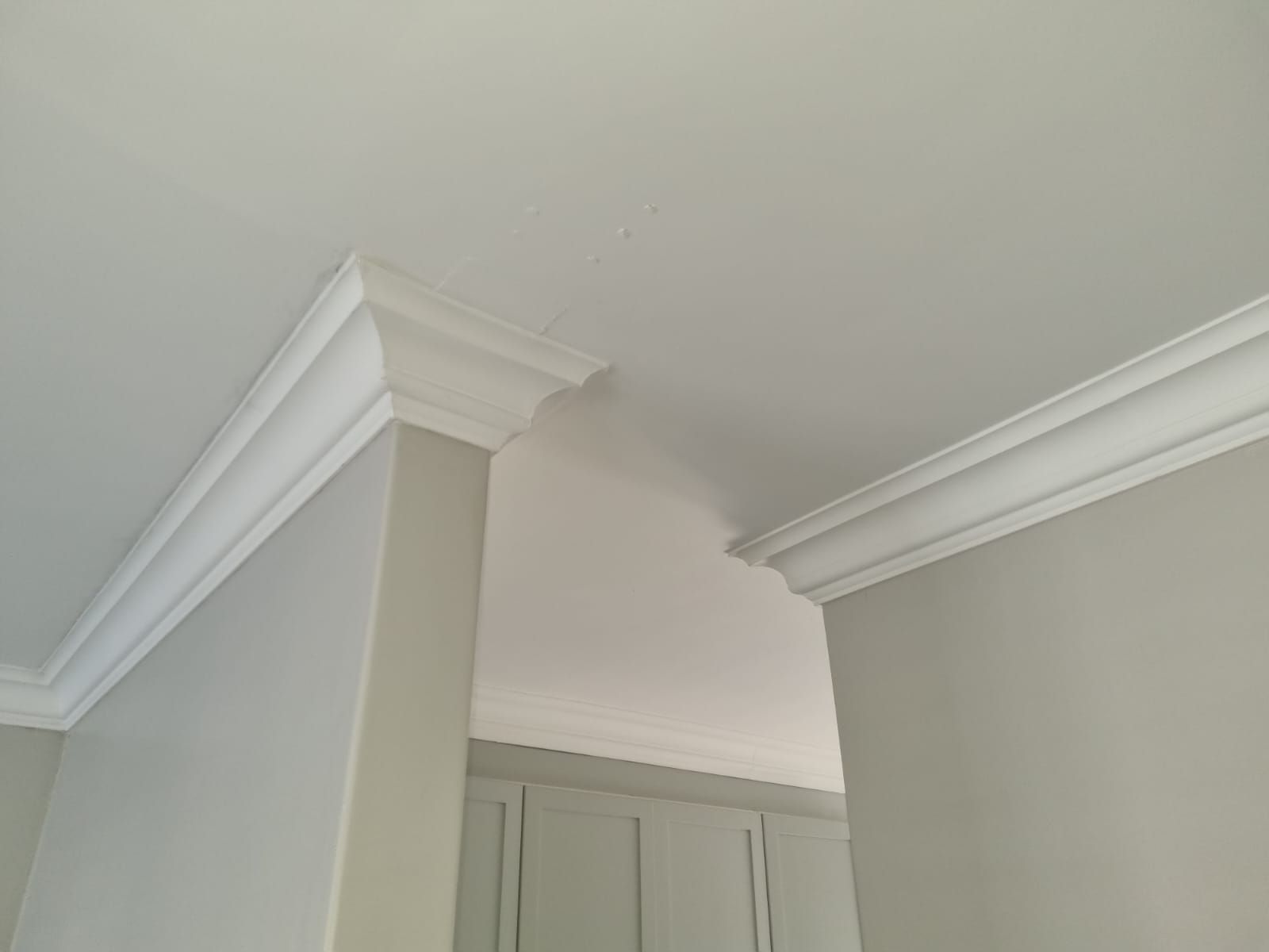A room with white walls and a white ceiling with crown molding.
