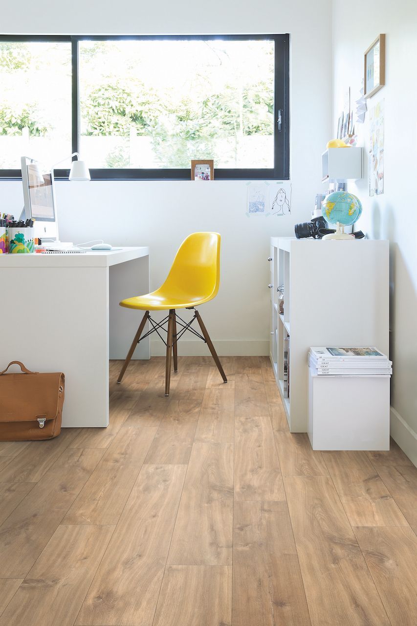 A home office with a wooden floor and a yellow chair.