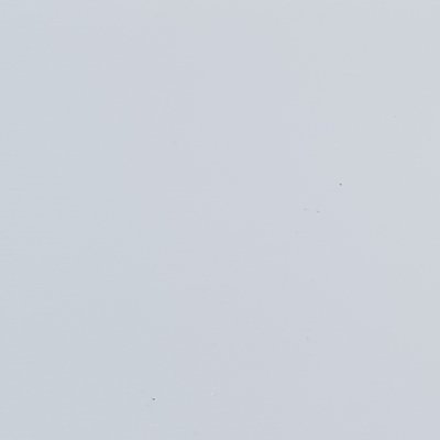 A close up of a white surface with a few small dots on it.