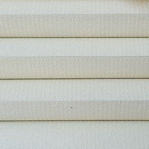 A close up of a white blind on a window.