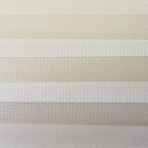 A close up of a white pleated blind with a pattern on it.