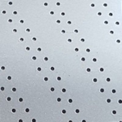 A close up of a piece of metal with black dots on it.