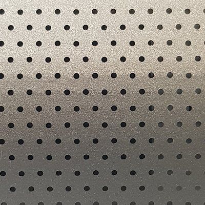 A close up of a metal surface with black polka dots on it.