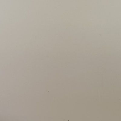 A close up of a white wall with a few small holes in it.