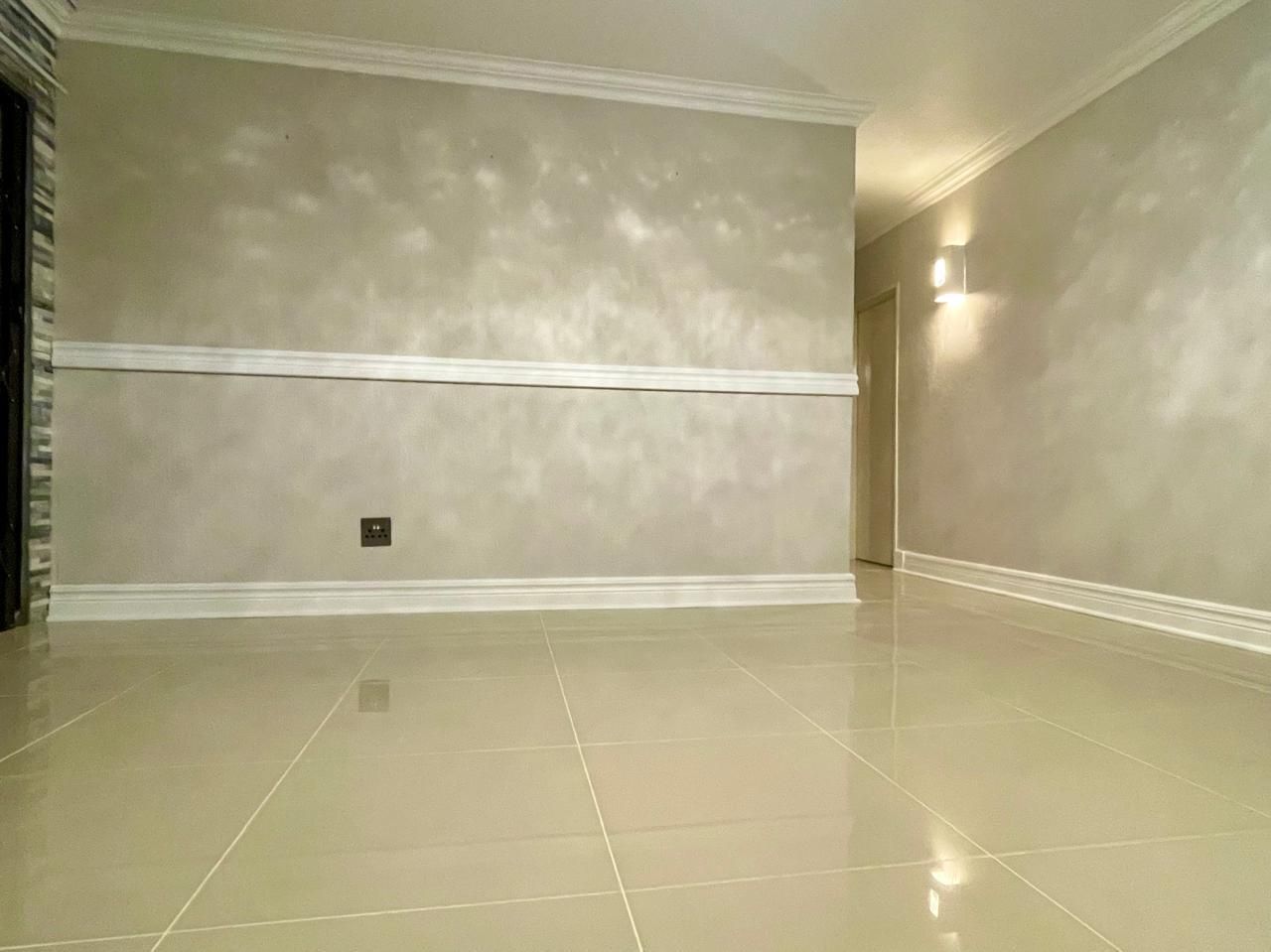 An empty room with a tiled floor and white walls.