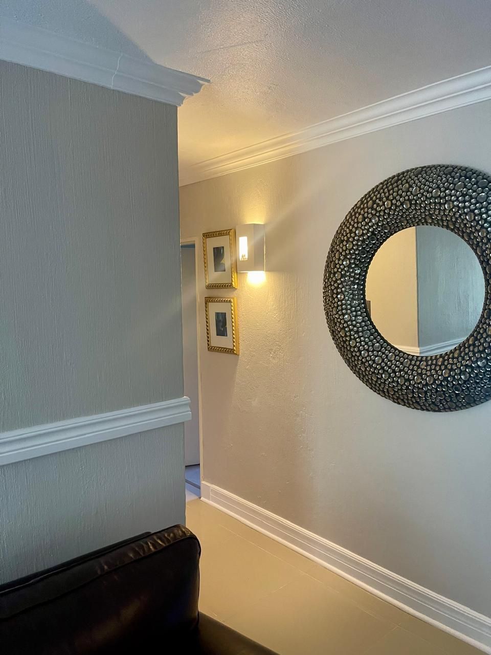 A hallway with a round mirror on the wall