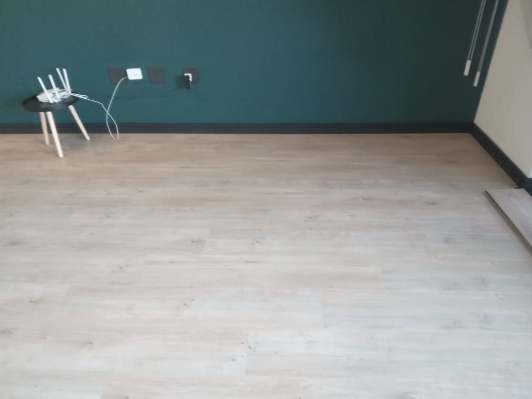 A room with a wooden floor and a green wall.